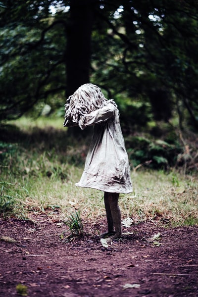 woman in white dress standing on brown dried leaves during daytime